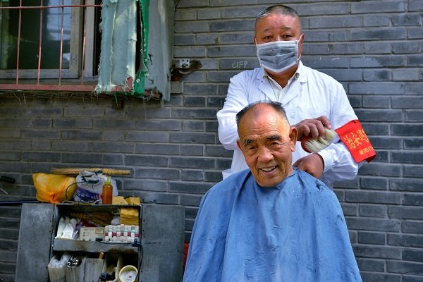 Local street barber at work in the hutongs
